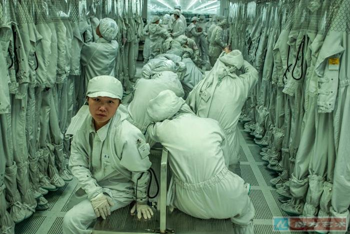 Zhan Youbing: Workers at the changing room of an electronics factory, Dongguan, China (2011)